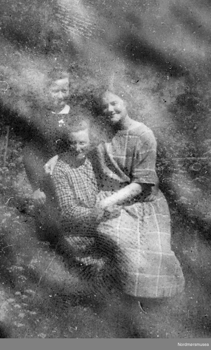 Foto av tre kvinner. Det er ukjent hvem vi ser på bildet, samt hvor og når bildet er tatt. Fotografiet er sterkt svekket. Fotoalbum som stammer fra Marie Opdal (f. april 1894 - d. februar 1981/82) gitt i gave av Torbjørg og Arild Karijord. Fra Nordmøre museums fotosamlinger.