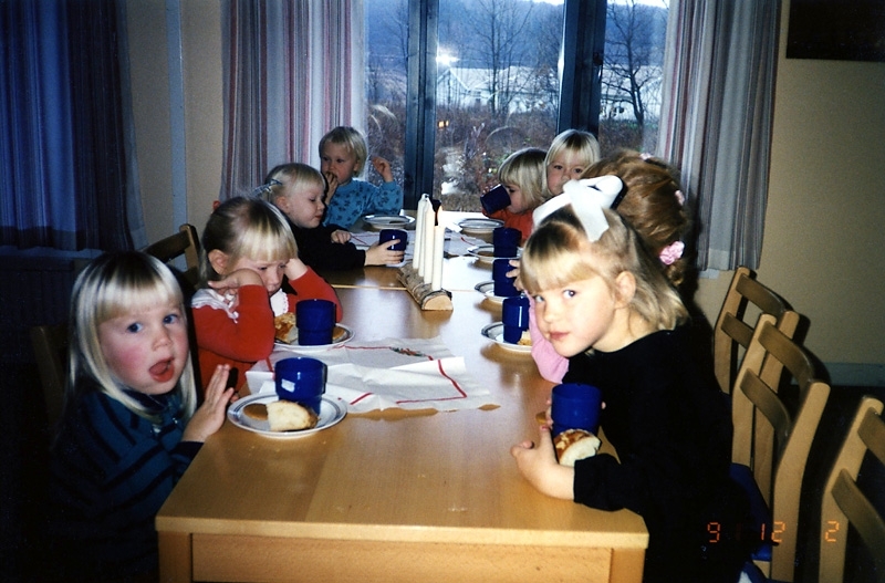 Kyrkans barntimmar i Apelgårdens kyrka 1991. Några barn sitter vid ett bord och fikar. I bakgrunden skymtar bostäder på Hedbäcksvägen.