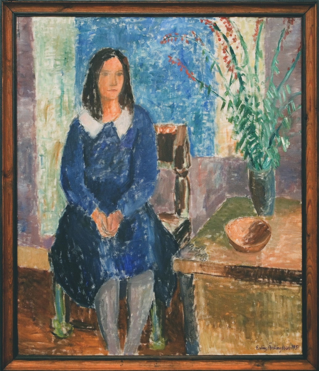 Oljemålning på duk, "Kväll" av Erling Ärlingsson. Interiör med blåklädd flicka sittande på en stol; t.h. bord med brun skål och vas med röda blommor.