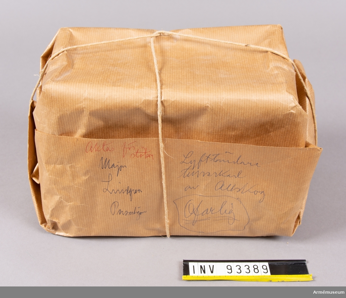 Paket i brun wellpapp med brunt snöre. Har sannolikt använts för att testa om det går att smuggla in ett paket som skulle kunna innehålla en bomb på svenska myndigheter. Innehåller äldre ofaliga elektriska komponenter för att efterlikna en verklig sådan från tiden efter andra världskriget. En av kartongerna har en märkning från augusti 1947.