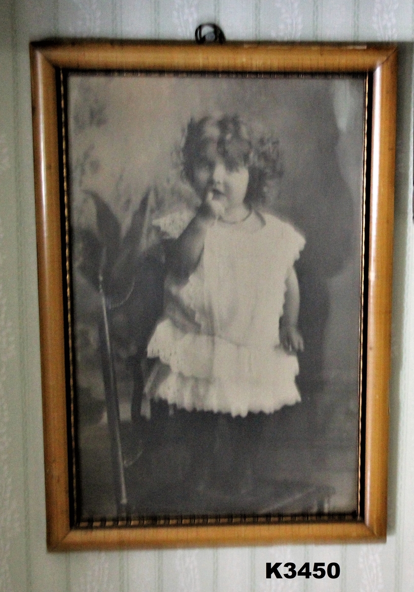 Svarthvitt-foto av en liten jente i hvit kjole.