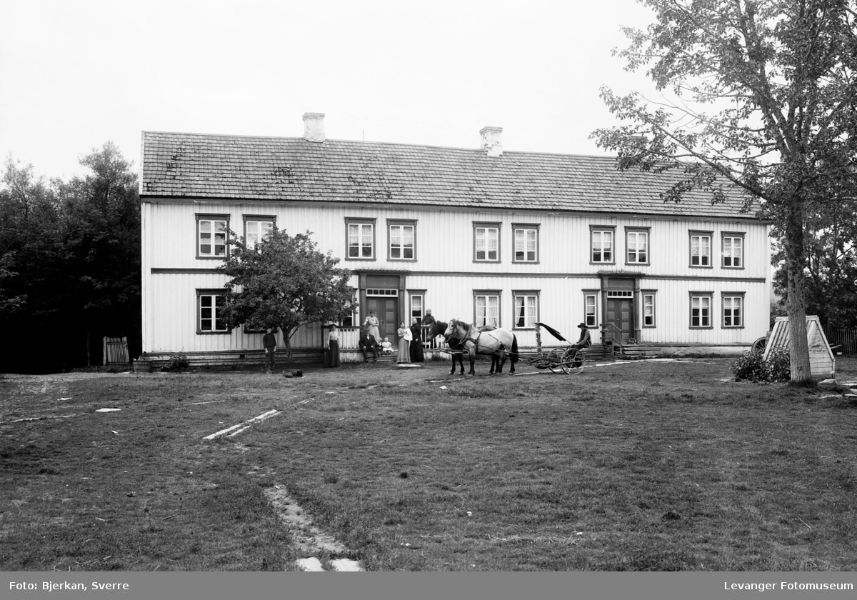 Stiklestad Nordre, Stiklestad, Verdal

Trønderlån, familien foran huset og hestene spent foran en slåmaskin på gårdsplassen.