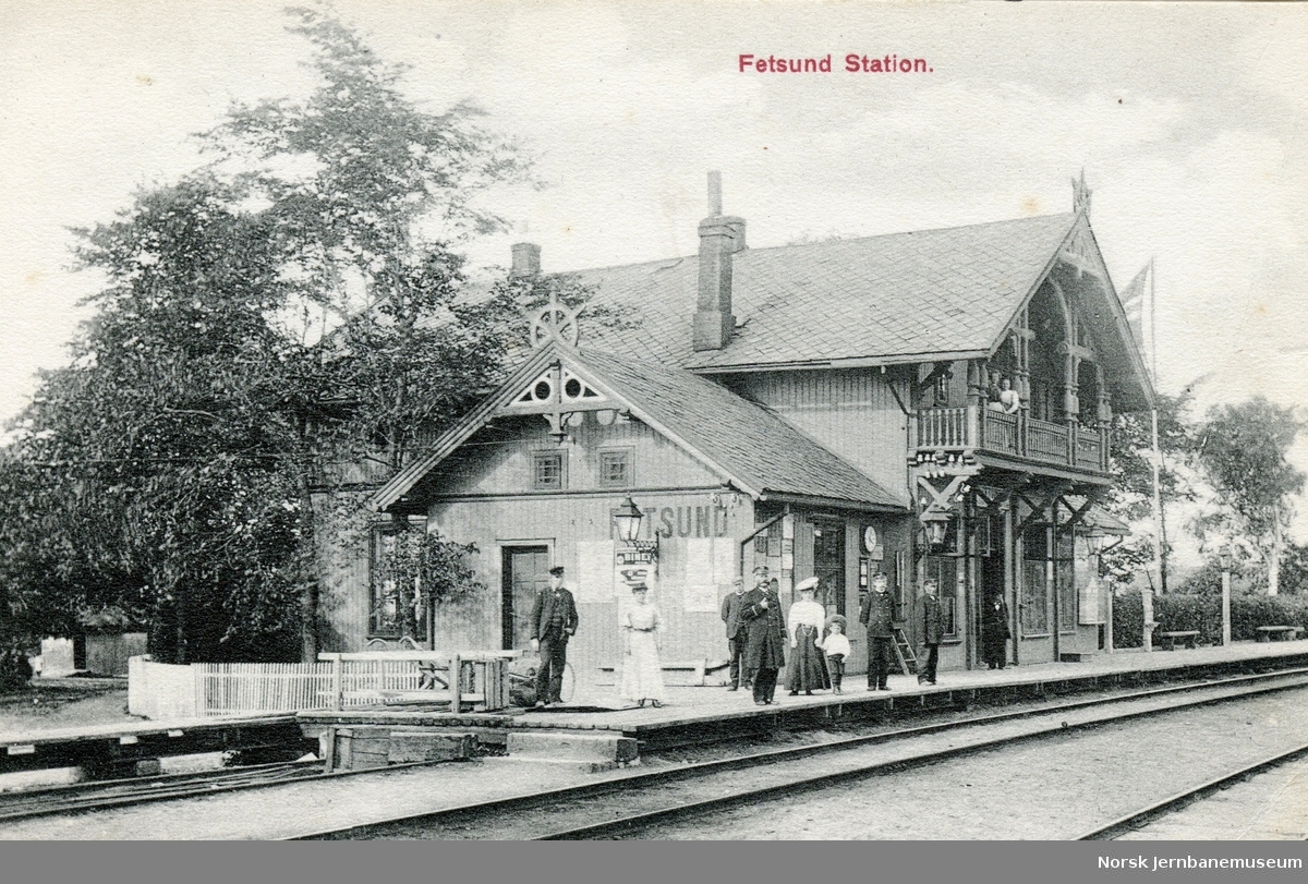 Fetsund stasjon. Stasjonsbetjening med famile på plattformen.