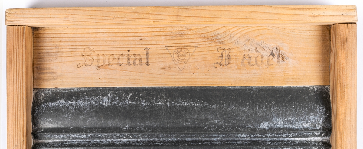 Tvättbräda av trä och plåt. Varumärket har ifyllts med blyerts. "Special Brädet" och "Hohult 1898".