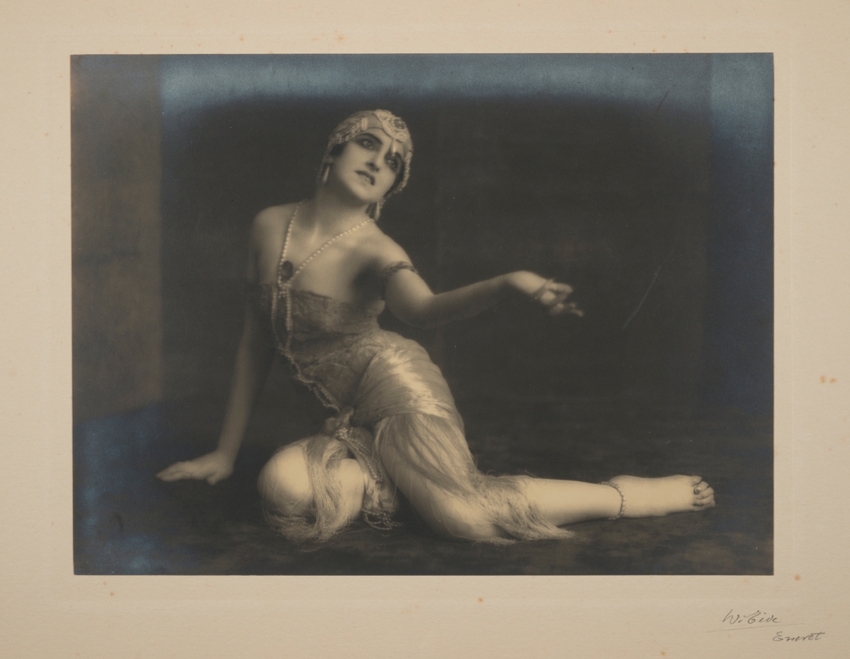 Kunstnerisk portrett av den berømte russiske ballettdanseren Vera Fokina, sittende på gulvet.
Fra 'Salome - De syv slørs dans'.