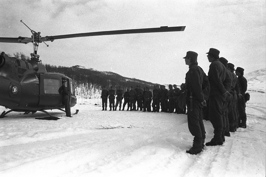 Befalsskoleelever oppstilt rundt et helikopter hører på en instruktør.