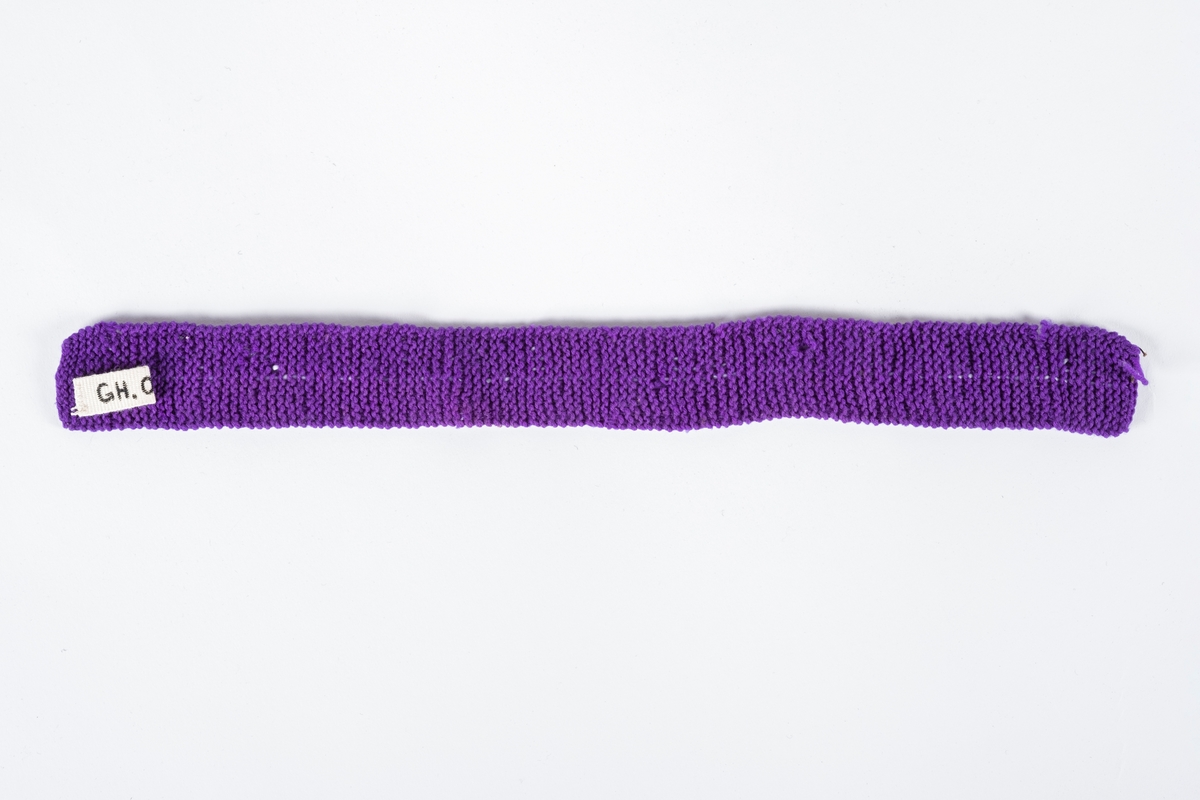 Lilla strikket bånd med perlebroderi.