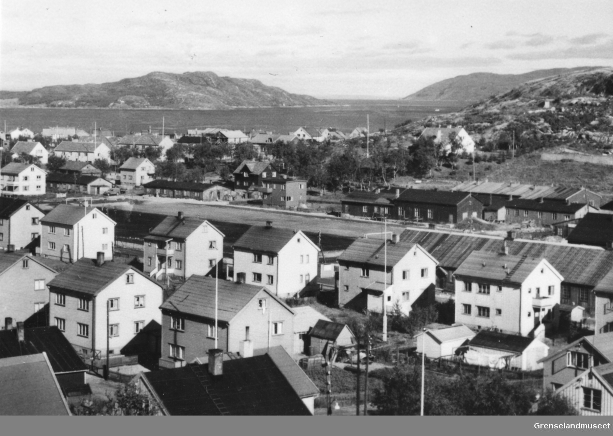 Gjenreisningshus i Parkveien, Kirkenes etter krigen, 1949-1950. Fotballbanen og skolebrakkene bak.