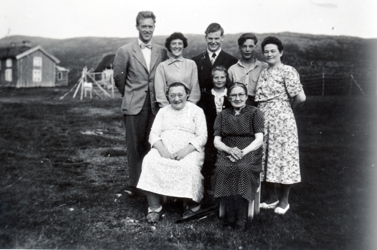 Familie i Hofsøya. Heimerstua i bakgrunnen.