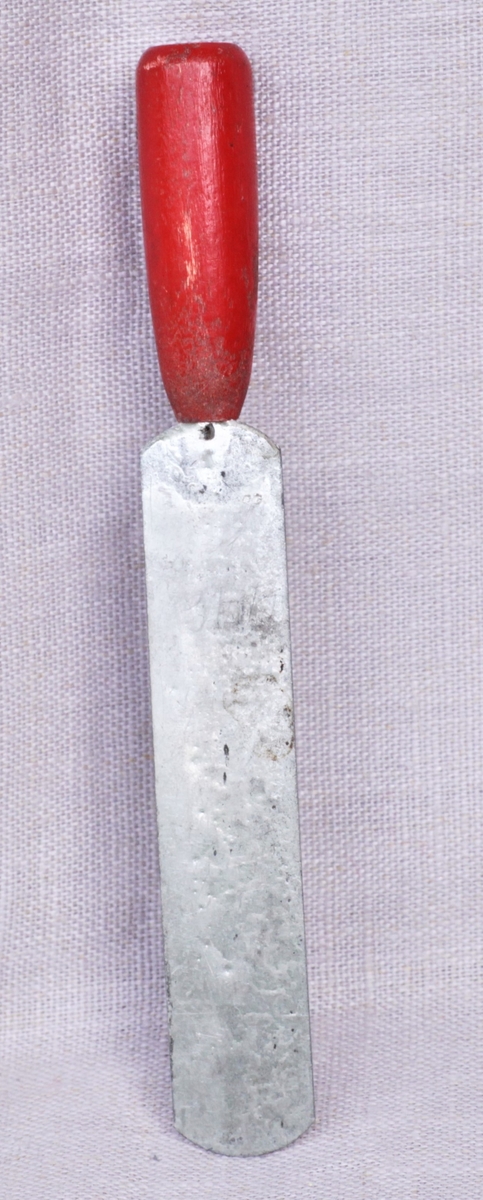 Lekesmørkniv av metall med rødt treskaft.
