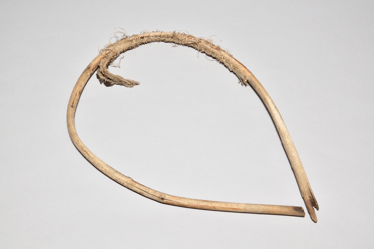 Lieskärm, "krag", av trä och linneväv. Oval ring av en böjd gren, ihopspikad upptill. Linneväv virad med tunt snöre på insidan av ovalen.