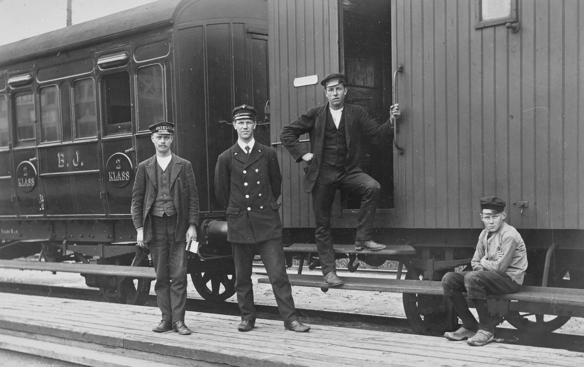 Personal framför tåg från Bergslagernas Järnvägar med bland annat en resgodsvagn samt en 2:a klass personvagn.
