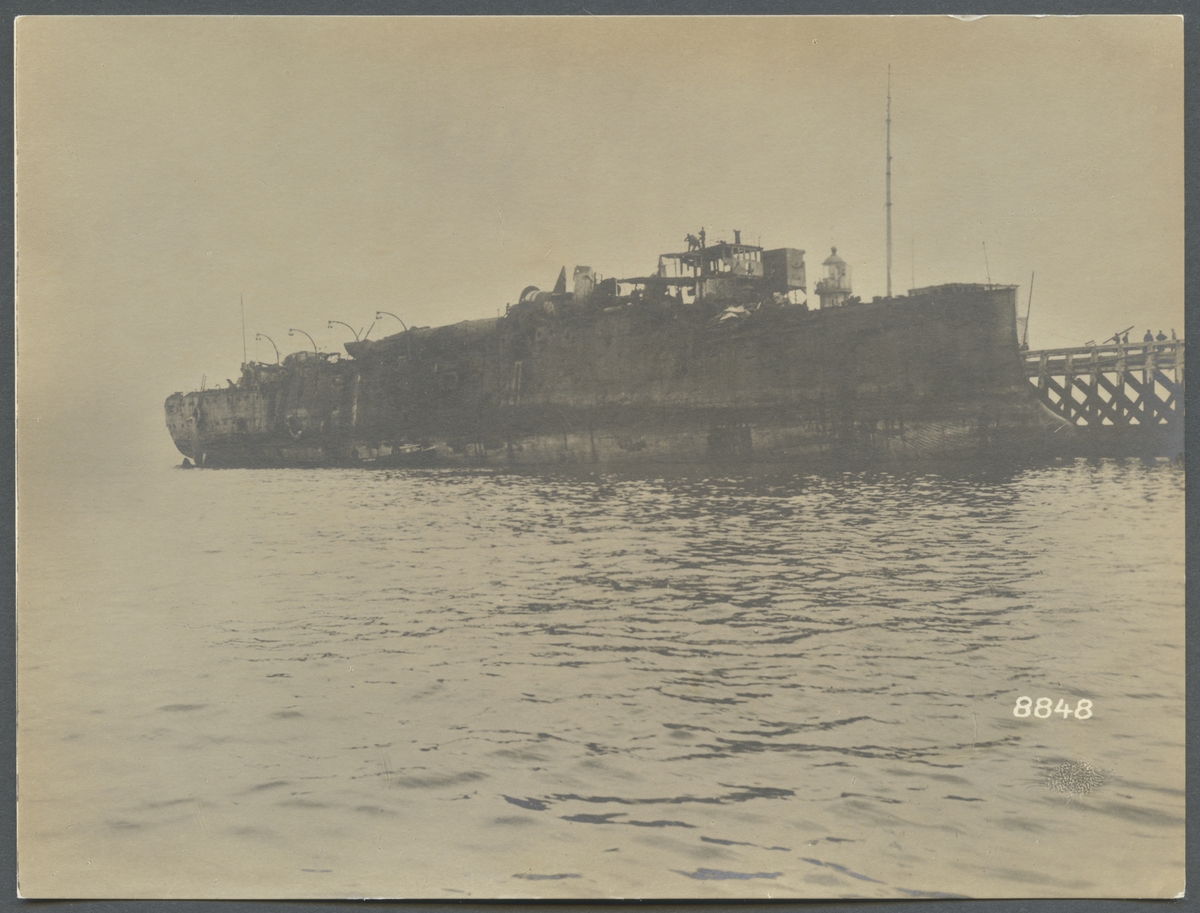 På bilden syns det engelska blockadskeppet HMS Vindictiv som gick på grund under Zeebryggeräden. Vraket bärgades och ligger här vid Zeebryggepiren i väntan på skrotning.
