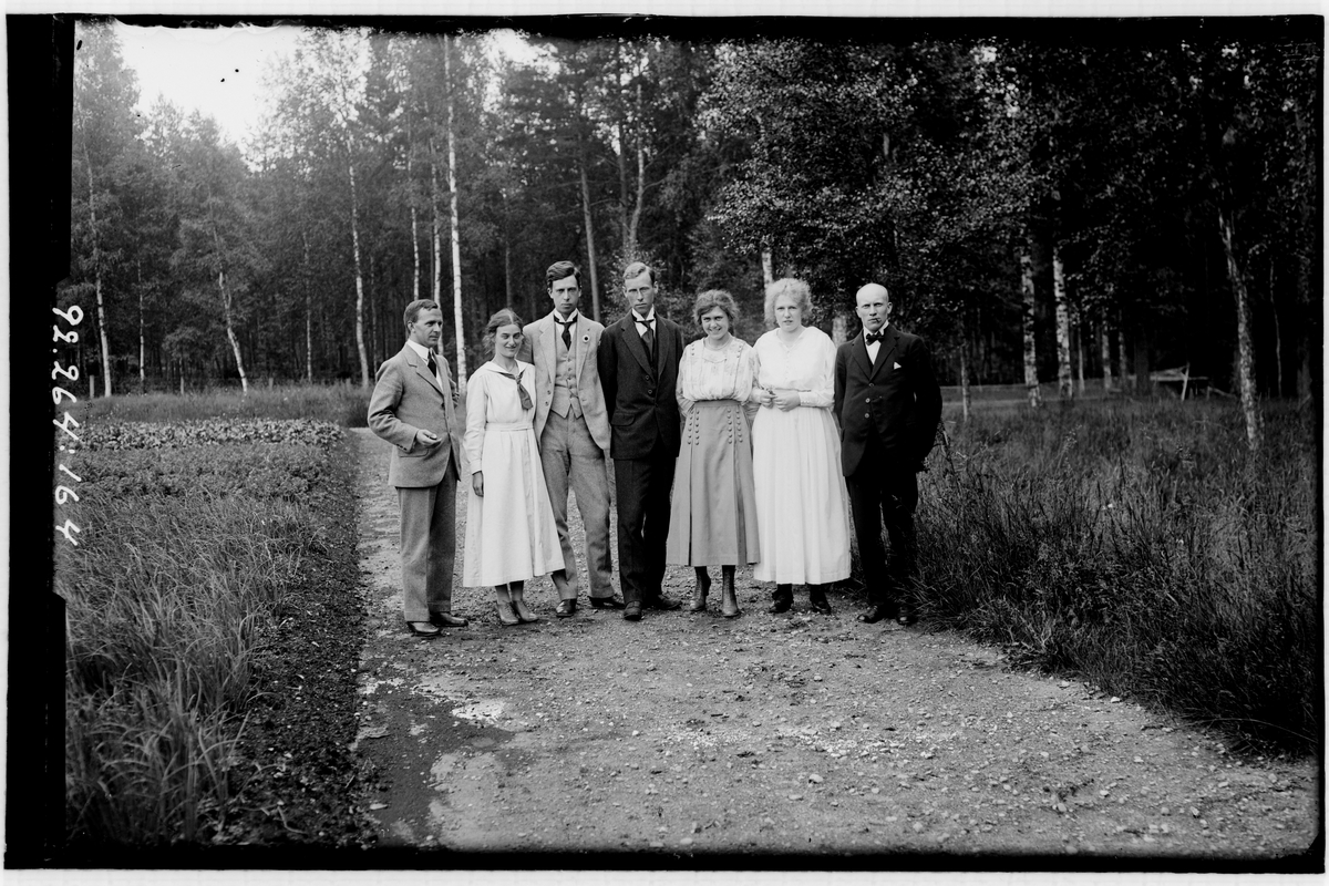 Hålahult sanatorium, exteriör, fyra män, tre kvinnor på en grusgång, björkskog som bakgrunden, uppklädda.