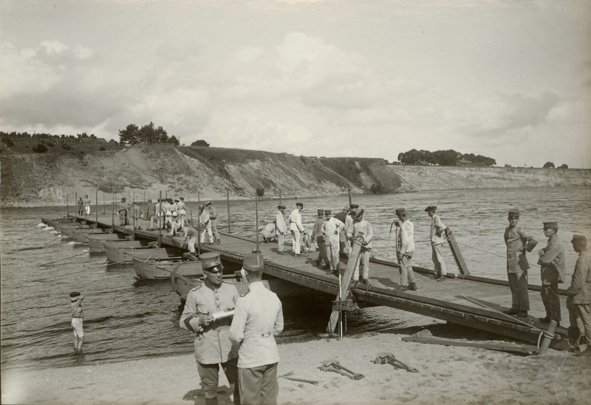Elever från Krigsskolan Karlberg bygger pontonbro över vattendrag.