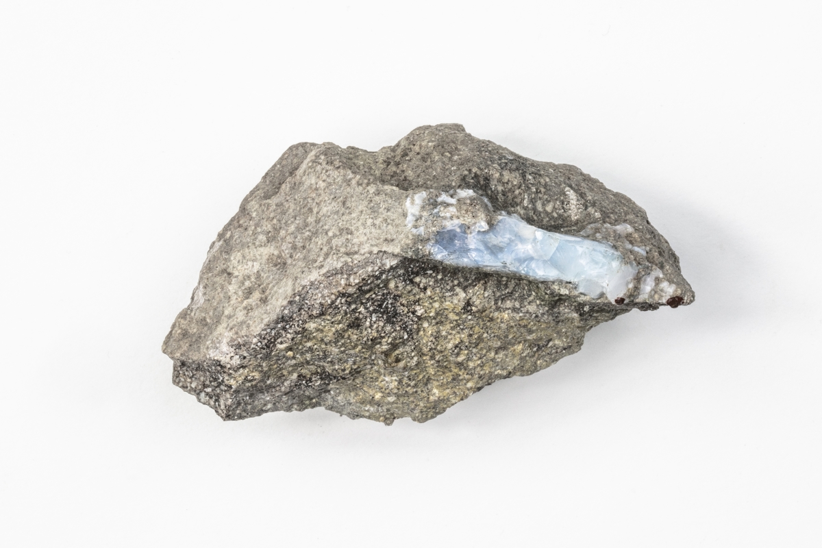 Ett mineral som är en opal och består av vattenhaltig kiseldioxid. Färgen kan variera mellan vit, grå, blå, grön, orange och svart. Detta exemplar är ljusblått. Exemplaret kommer från dåvarande Österrike/Ungern och ingår i Adolf Andersohns samling.