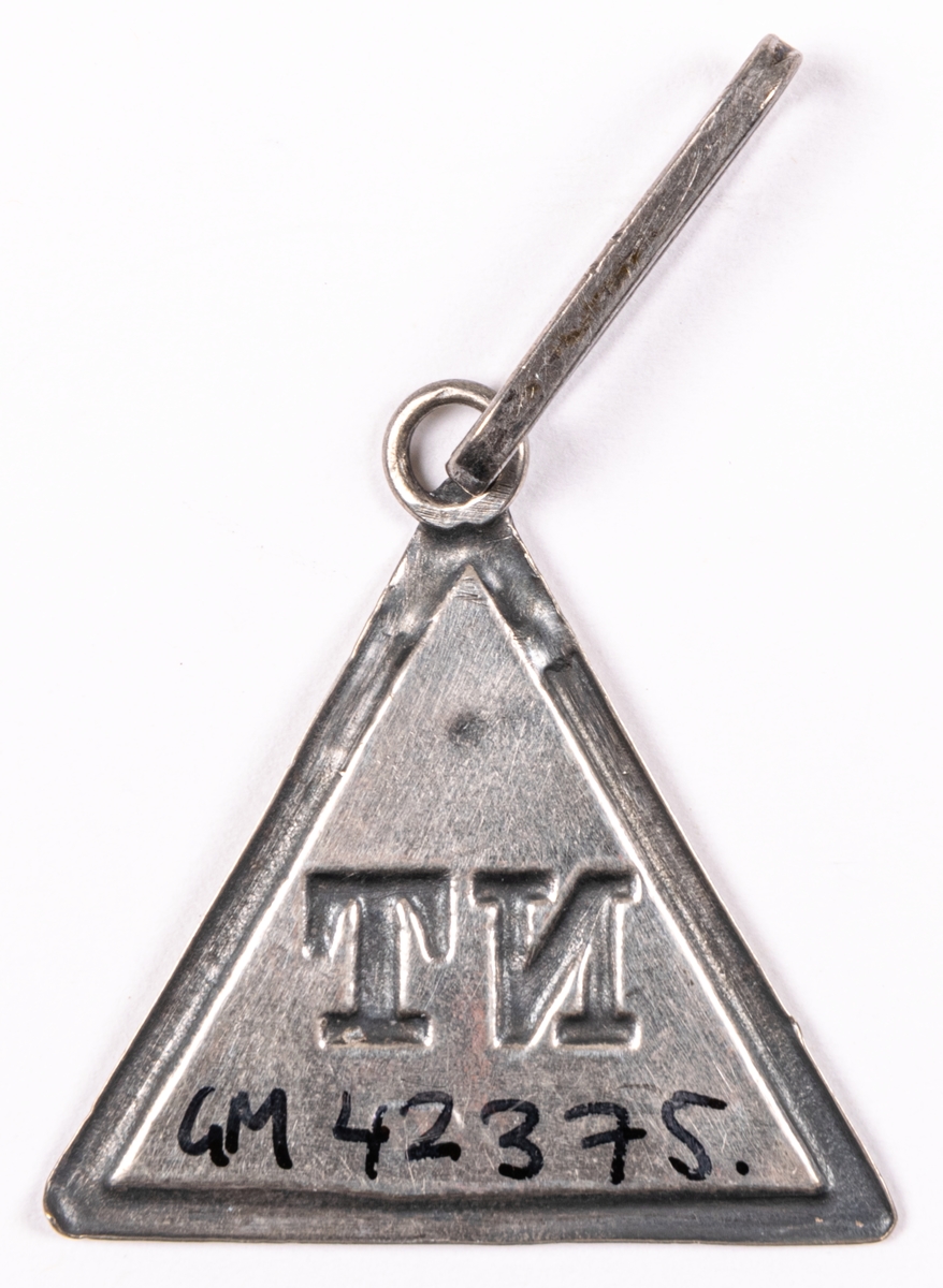 Ordensdekoration i silver, från Sällskapet NT, Gävle.
Triangelformat hänge med bokstäverna N T, samt silverstämplar:
S5 JOÖ kontrollstämpel G.