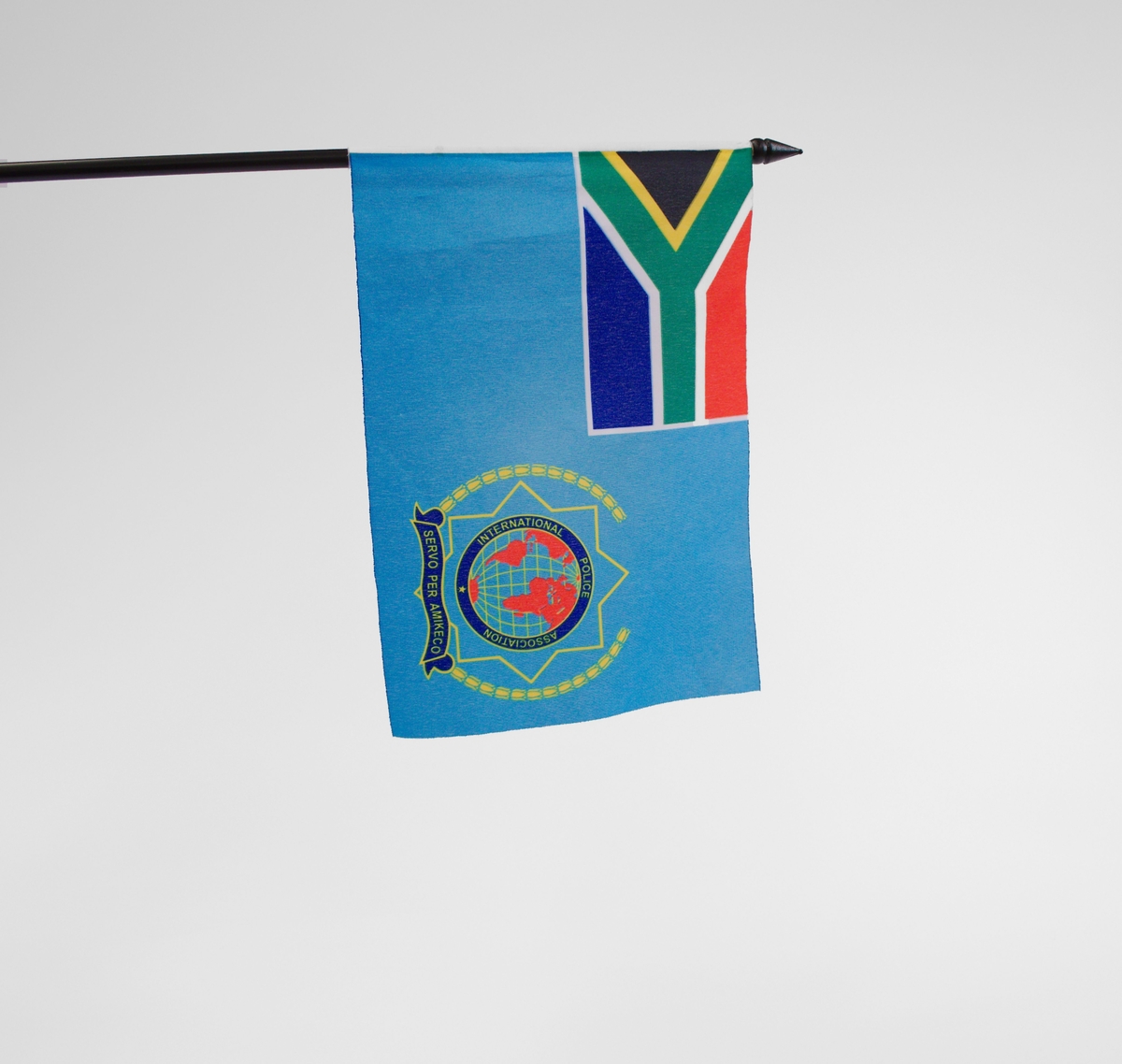 Sort flaggstang med blått flagg. Det blå flagget avbilder både IPAs logo og Sør-Afrikas flagg.