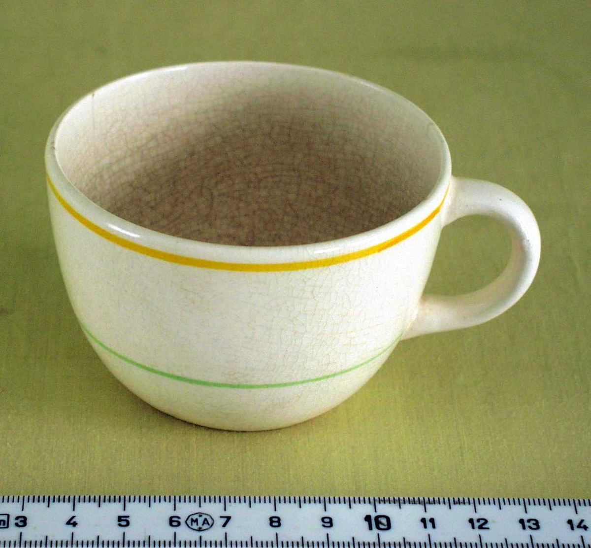 Hvit, keramisk kaffekopp med hank. Dekorert med en orange og en grønn stripe på utsiden.