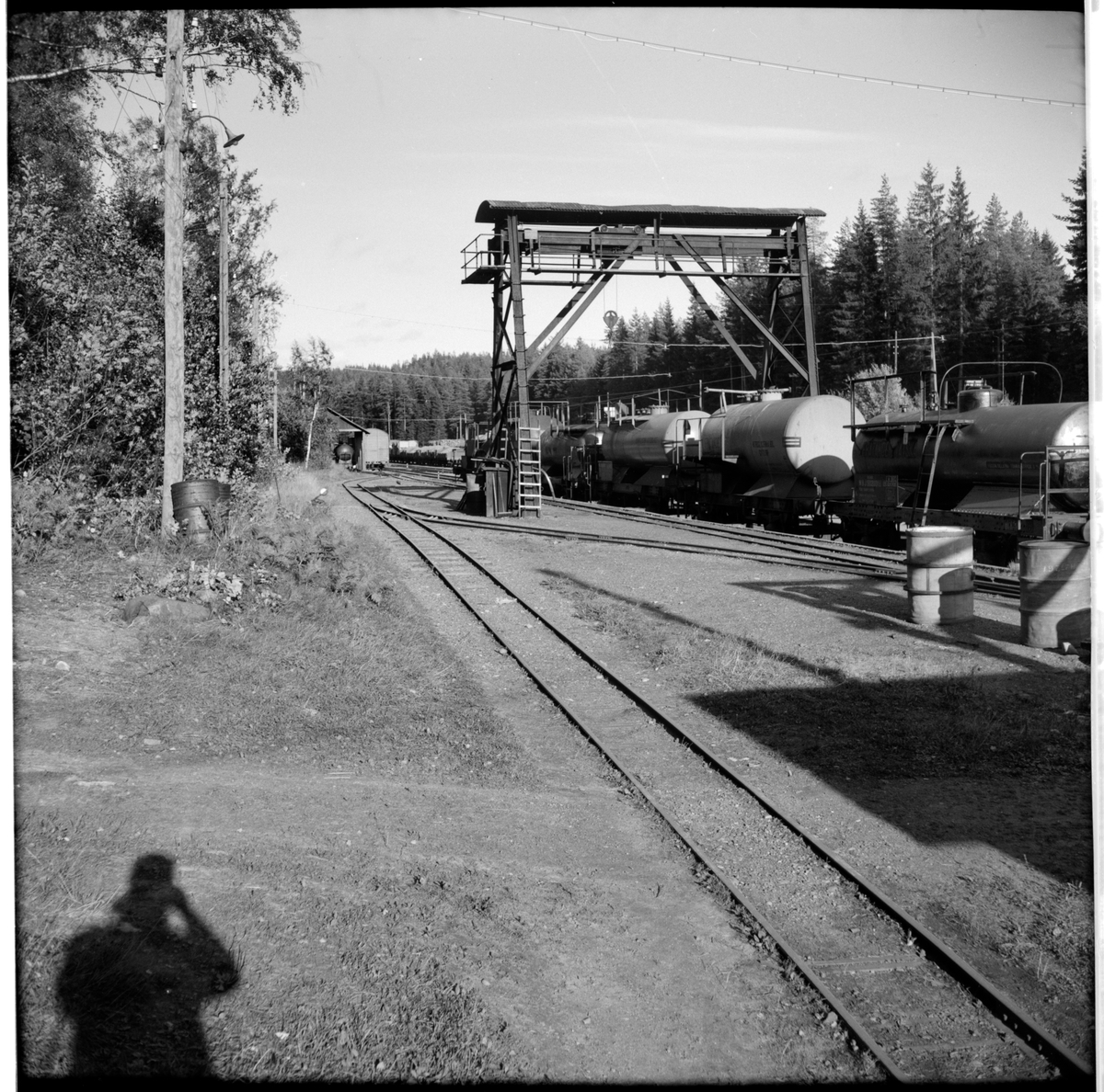 Till höger i bild Nora Bergslags Järnväg, NBsJ 50200. Godsvagnar lastade med cisterner under traversen.