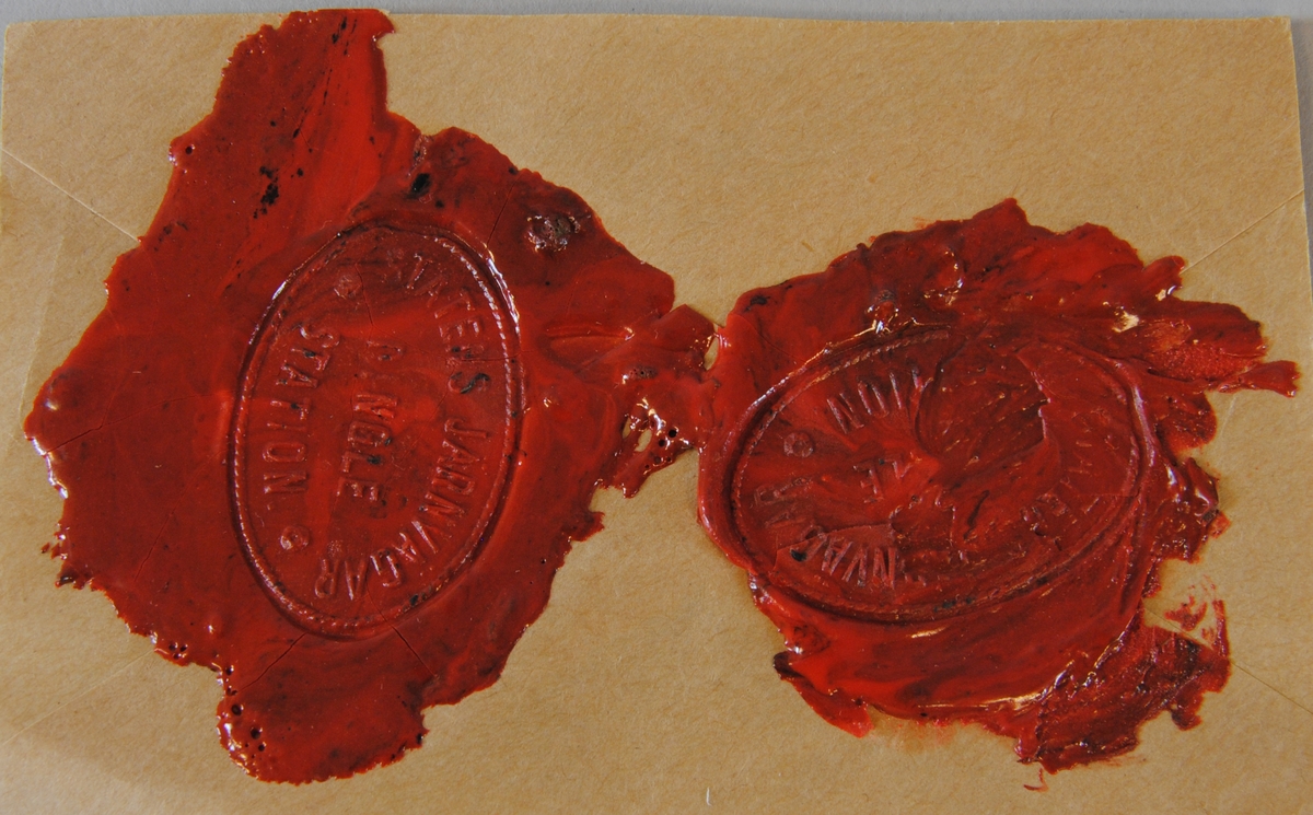 Två sigillavtryck av rött lack på brunt papper. Avtrycken är formade som en liggande oval.