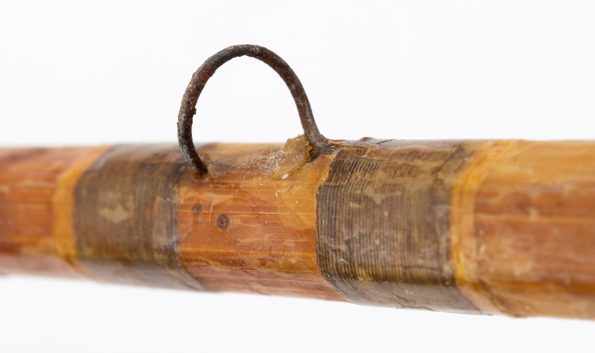 Ei tredelt enhånds fiskestang av splitcane (bambus) for fluefiske, prototyp av Einar Sønsterud. Håndtaket er av kork med en kule, sannsyligvis av bly nederst. Snellefeste, to metallbånd som omslutter håndtaket, tres over snellefoten. Alle stangringene er intakte. Sammen med toppringen, er det 8 ringer. Stangsurringene av tråd er påført lakk og er tilnærmet intakte. Stangdelenes holker er sannsynligvis av messing.
Splitcanestanga er bygd opp av seks forskjellige sammenlimte bambusdeler (spildrer) som er limt sammen.

I mottaket fulgte det med en topp som framstår som ubrukt. Ved registrering antas det at denne ekstratoppen er laget til Sønstruds prototype. Ekstratoppens farger og proporsjoner stemmer overens med prototypens utforming.