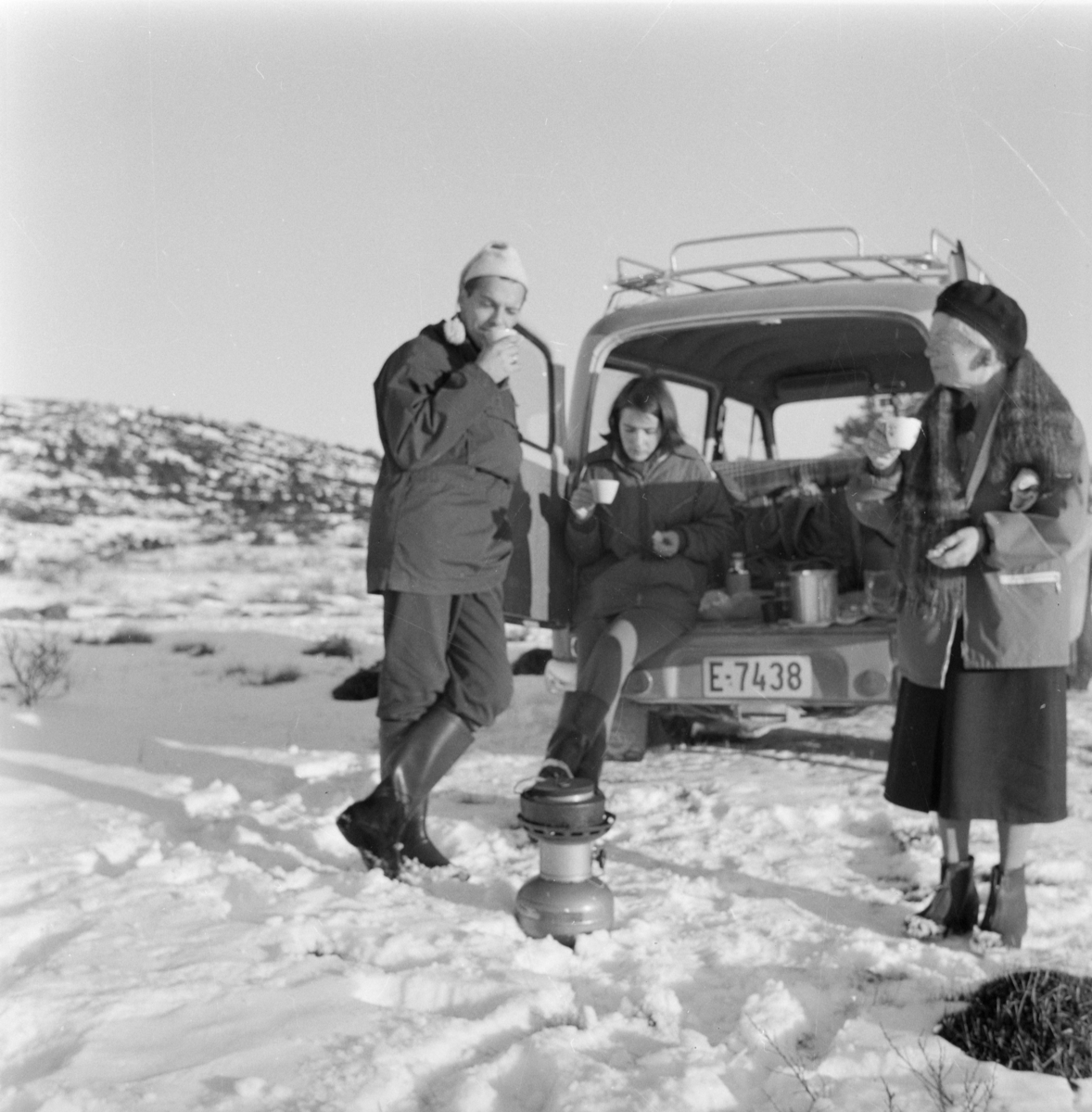 Tre personer på biltur - koking av kaffe på primus - stasjonsvogn E-7438