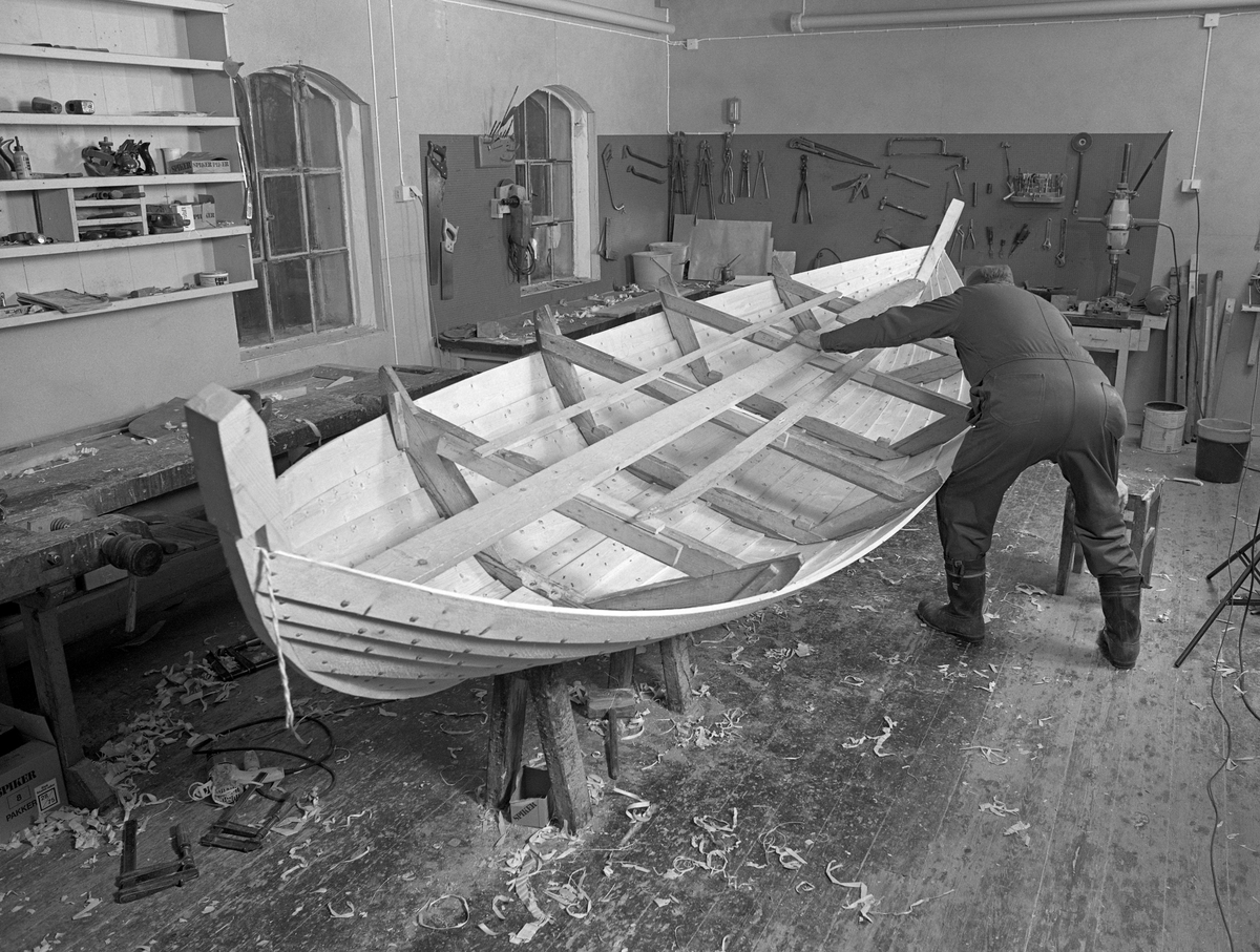 Bygging av fløterbåt (Flisa-båt) Nov. 1984. Glomma fellesfløtningsforenings verksted på Flisa. Båten vippes rundt på bukken, for å komme til med å jobbe på den andre halvdelen av båten.