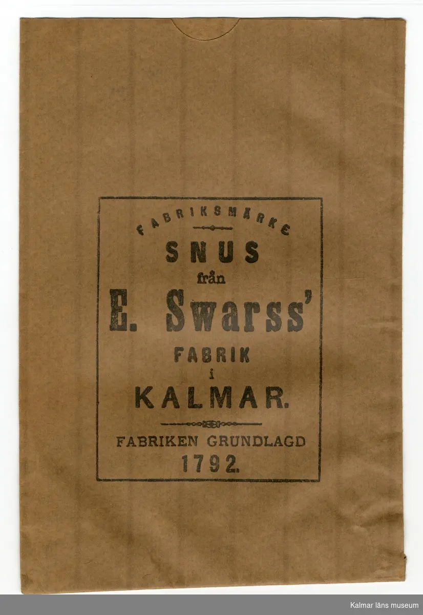 KLM 39502:119. Påse, snuspåse. 2 stycken. Av brunt papper, svagt randiga. Tryckt svart text: Fabriksmärke SNUS från E. SWARSS fabrik i KALMAR. Fabriken grundlagd 1792.