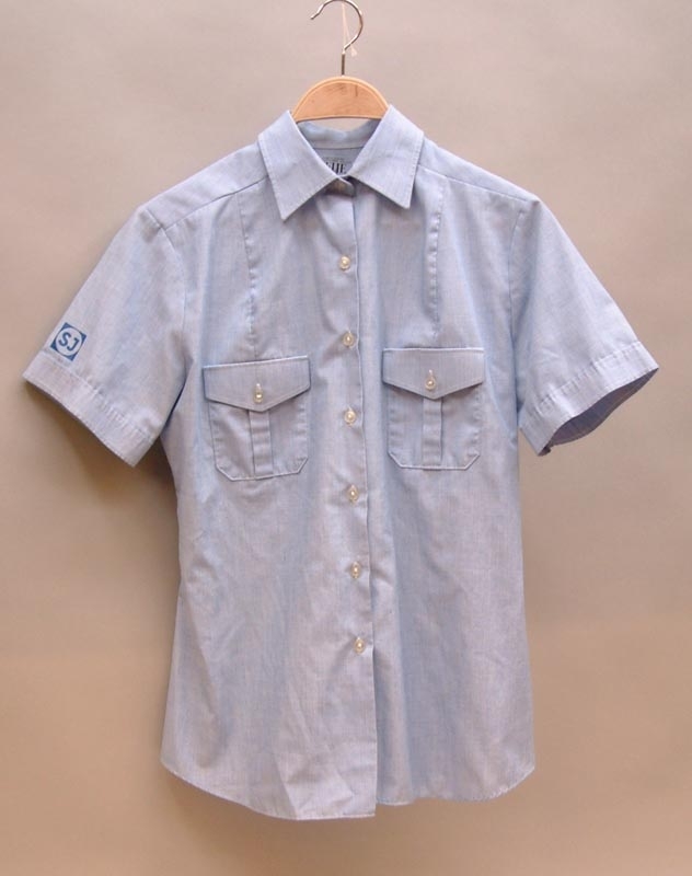Ljusblå kortärmad skjorta med två bröstfickor.
Mörkblått SJ-tryck på höger ärm.