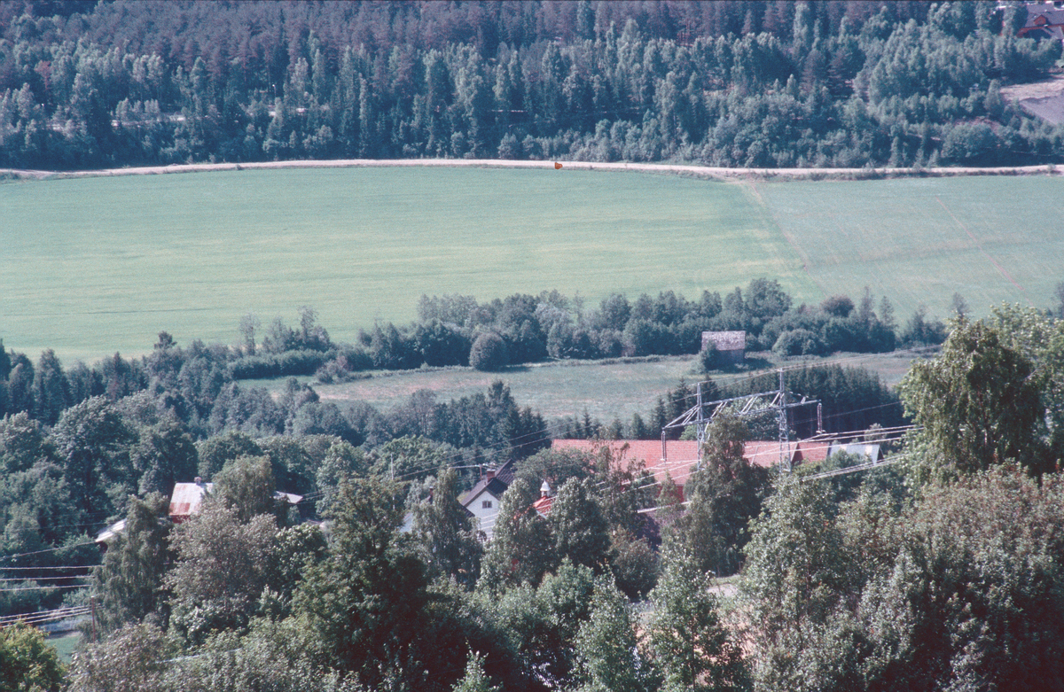 Lillehammer.  Langøya nordøst for Jorekstad.  Langøya er det lille jordet midt i bildet med den grå løa.  Her ble det anlagt midlertidig medialandsby til OL 1994.  Gausa går mellom Langøya og det store, røde taket.  Utsikt mot sør fra Jørstadhøgda.