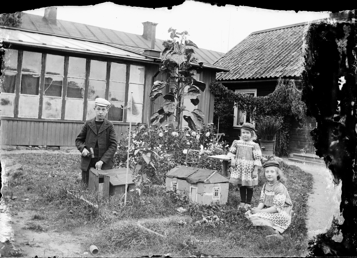 Josef, Sara och Tyra Edhlund leker i trädgården, Guldskäret, Östhammar, Uppland