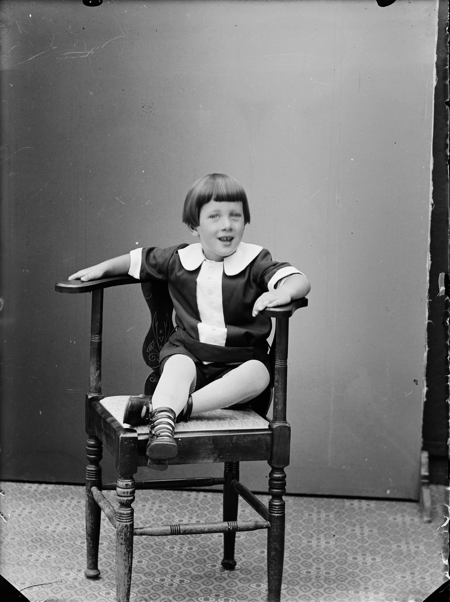 Ateljéporträtt - ett barn sittandes på en stol, Alunda, Uppland