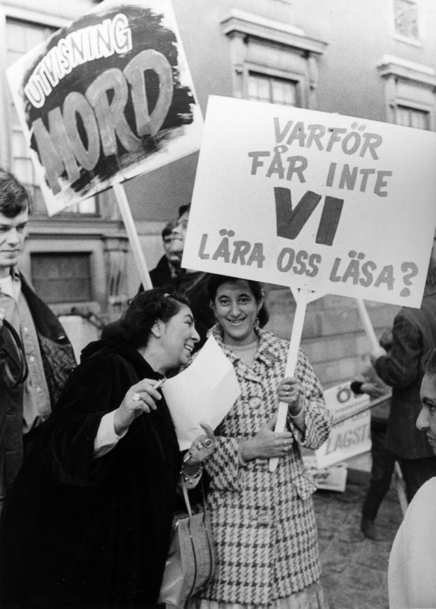 Demonstration till förmån för 47 utvisade romer i september 1969. Demonstranterna kräver rätt till undervisning och att lära sig läsa. Under 1960-talet lyftes romernas situation upp i ett nytt offentligt ljus och blev en politisk fråga. Under 1968 anländer till Sverige den grupp romer som i media kom att kallas för ”de 47”. Nu startar en av de största kampanjerna för flyktingar på 1960-talet. För första gången väljer romska flyktingar att söka asyl av politiska istället för humanitära skäl. Familjerna hade under 1930-talet flytt Polen via Italien, Frankrike och Spanien. Många av deras släktingar hade mördats under förintelsen. I Frankrike hade de blivit offer för ny diskriminering, förnekats arbete och förvisats till getton. Debatten i Sverige blir livlig och intrikat, men den 9 oktober 1969 fick "de 47" avslag på sin ansökan och skulle därför utvisas till Frankrike, där de senast kommit ifrån. Familjerna får nu lämna Roo gård utanför Åkersberga, där de har fått bo under en tid, för att åka till Göteborg. Men en timme innan båtens avgång mot Amsterdam meddelar holländska myndigheter att familjerna inte kommer tillåtas stiga av i Amsterdam, då man inte vill låta dem resa genom Holländskt territorium. I Göteborg blir det nu svårt att hitta natthärbärge, då inga hotell vill ta emot familjerna. De får först bo på ungkarlshotell och sedan tillbringa fyra nätter på gamla Hvitfeldtska gymnasiet (troligen Högre Latinläroverket vid Hvitfeldtsplatsen) där socialtjänsten inrett sju gamla lärosalar för ändamålet. Efter en vecka får familjerna åka vidare till Amsterdam, där de sedan eskorteras vidare av holländska myndigheter.