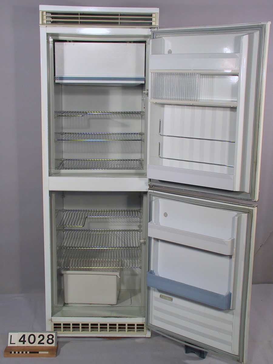 Kombinerat kyl- och svalskåp Elektro-Helios med två dörrar. Kylskået är vitlackerat med handtag och plastdetaljer i grått utförande. Logotypen är i svart, rött och silver. Ventilationsgallren är utförda i grå plast.