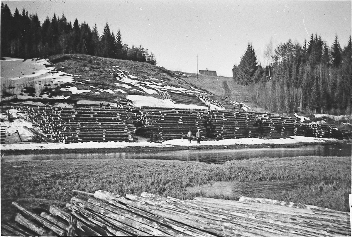Tømmervelter ved Grimebrua i Sigdal, med Noss på bakketoppen. Tømmeret ble lagt lagvis (eller i "floir", lagt i hus) så det skulle få tørk før det gikk i fløtningen. Tømmeret ble lagt slik da det ble merket.