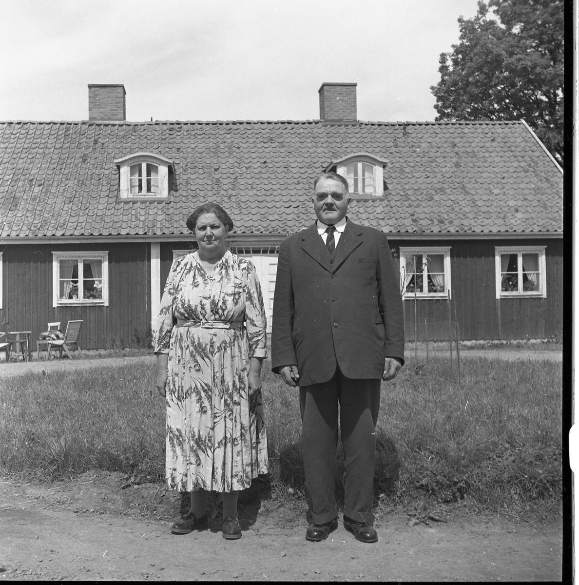 En man och kvinna fotograferad framför ett envåningshus med locklistpanel. Det är paret Rut och Gunnar Sääv.