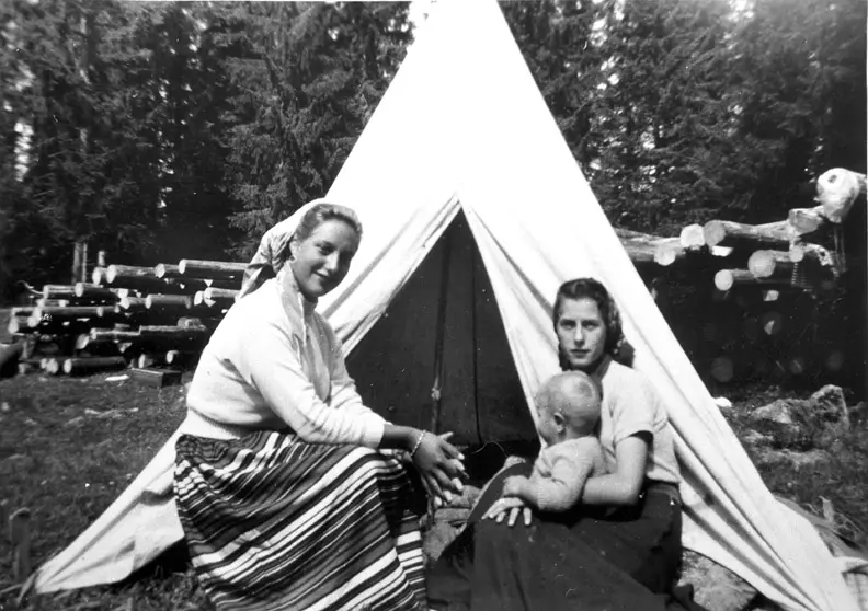 Two neat traveling women with a child on a meadow.