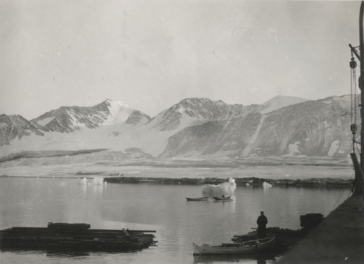 Landskapsbilde ved Ny-Ålesund. I forgrunnen er en mann i arbeid med å ...