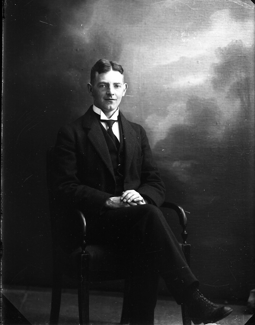 Porträtt av en ung man i kostym.