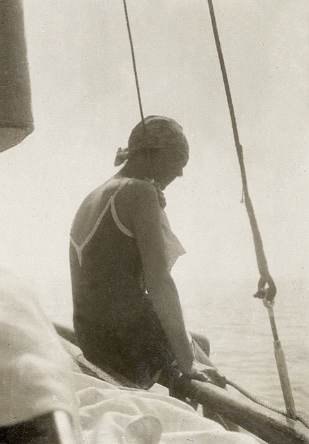 En ung kvinna i baddräkt på en segelbåt.