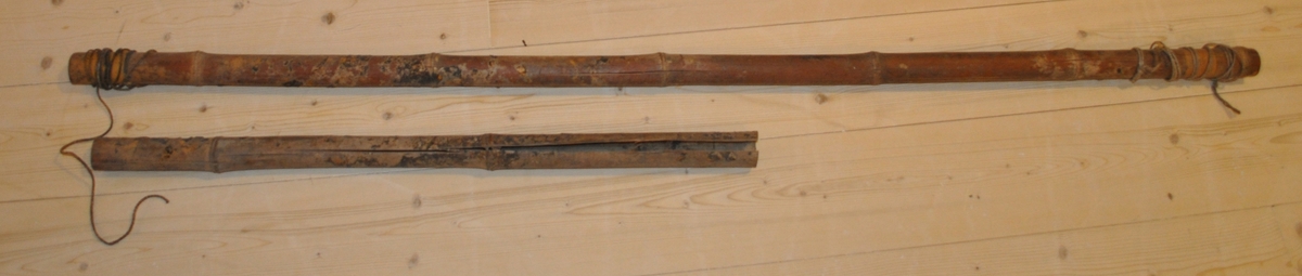Två bambustänger. A: försedd med snöre i ändarna som är virat runt staven. B: sprucken.