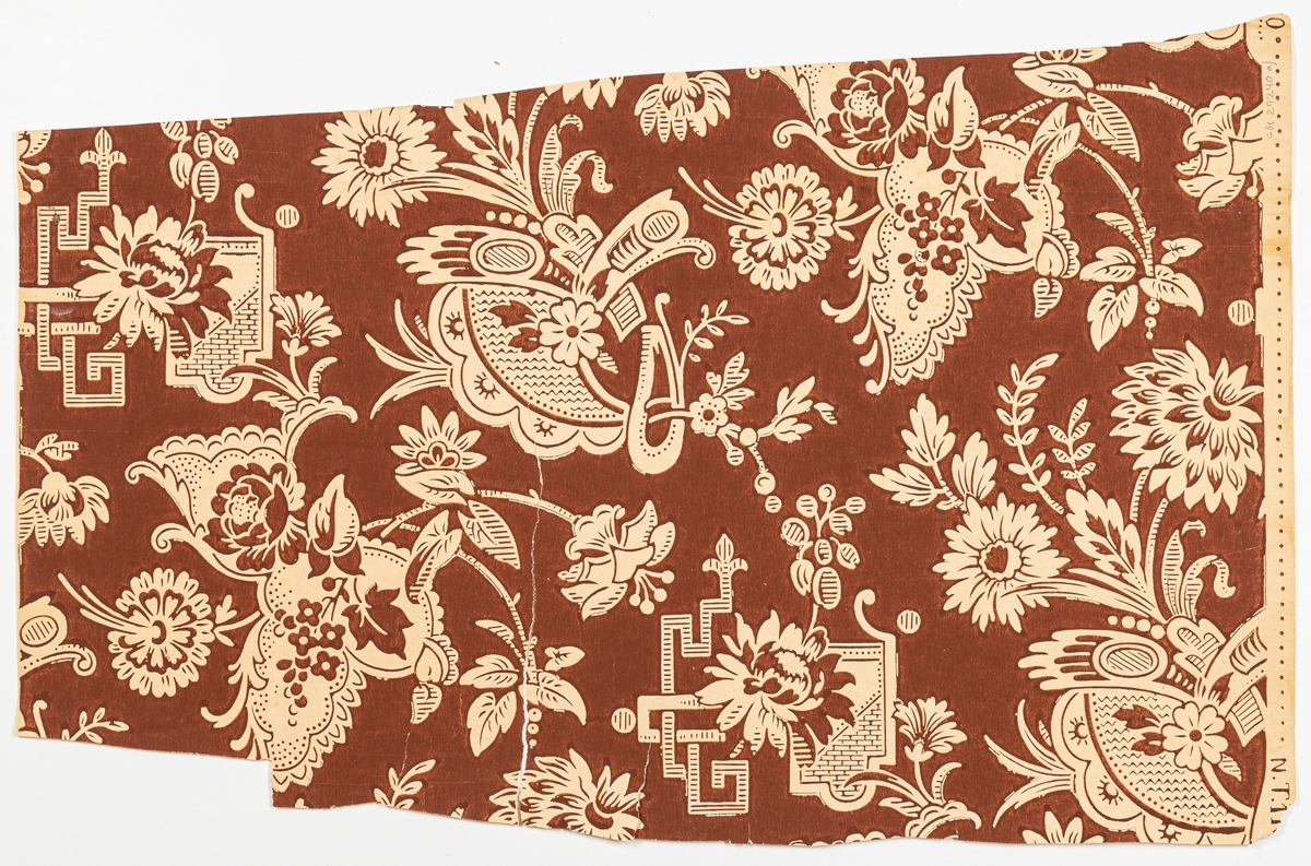 Tapet med mönster av krysantemum, rosor och japanskt inspirerad ornamentik mot påtryckt rödbrun fond. Enfärgat tryck i rödbrunt på obestruken botten. Papprets färg är synlig genom utsparningar i mönstret. Tillverkad vid Norrköpings tapetfabrik.'