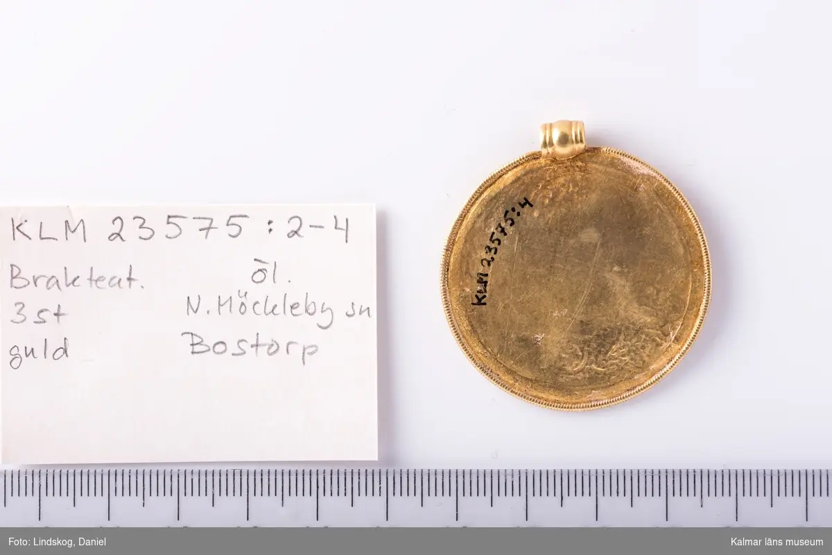 KLM 23575:4  Brakteat, av guld. Skatten ursprungligen nedlagd i en lerkruka av vilken fragment återfanns.