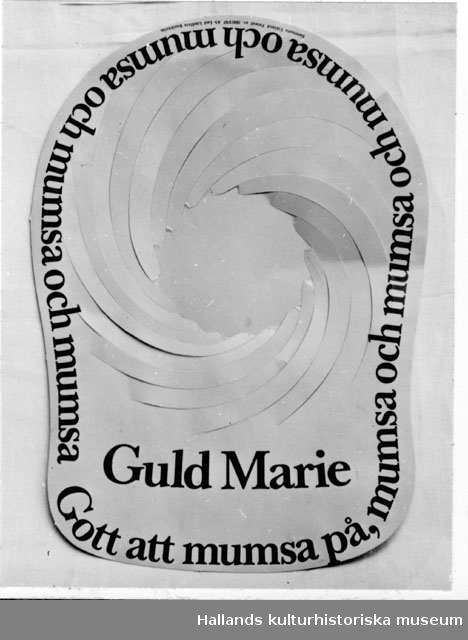Kartongskiva genomstansad med spiralmönster vilket låter en kulle bildas, då mössan sättes på huvudet. Gul med svart reklamtext: "Guld Marie" "Gott att mumsa på". I mindre bokstäver: "Satatuote Finland Patent nr. 36912/67AB Leif Lindfors, Stockholm".