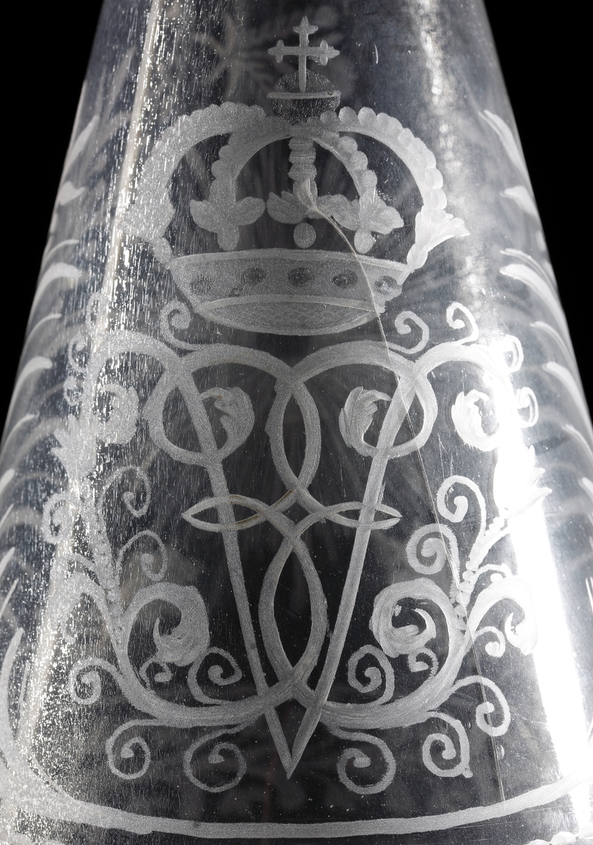 Vinkaraff, med halsring, utan propp. Graverat motiv i form av drottning Ulrika Eleonoras monogram under kunglig krona. Bred runtgående bladbård på hals och bål. Strålande nordstjärna på motsatta sidan.
Inskrivet i huvudkatalogen 1968.