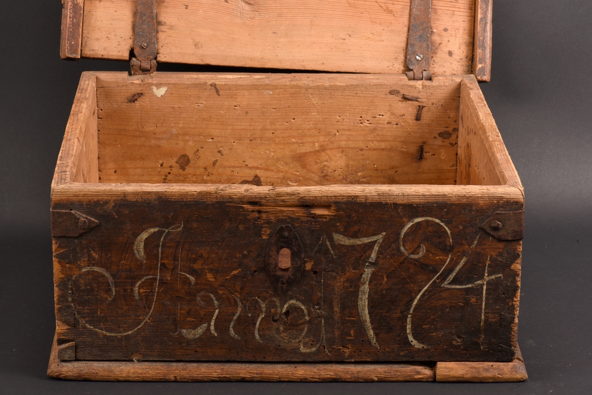 Rektangulärt skrin med plant lock tillverkat av furu. Målat i brunt, med dekor på lockets ovansida, en målad krans i rött och vitt. På framsidan ditmålat årtal "1794" i vitt. Beslag, spikar och gångjärn i järn. Nyckel saknas och ett gångjärn sitter löst.