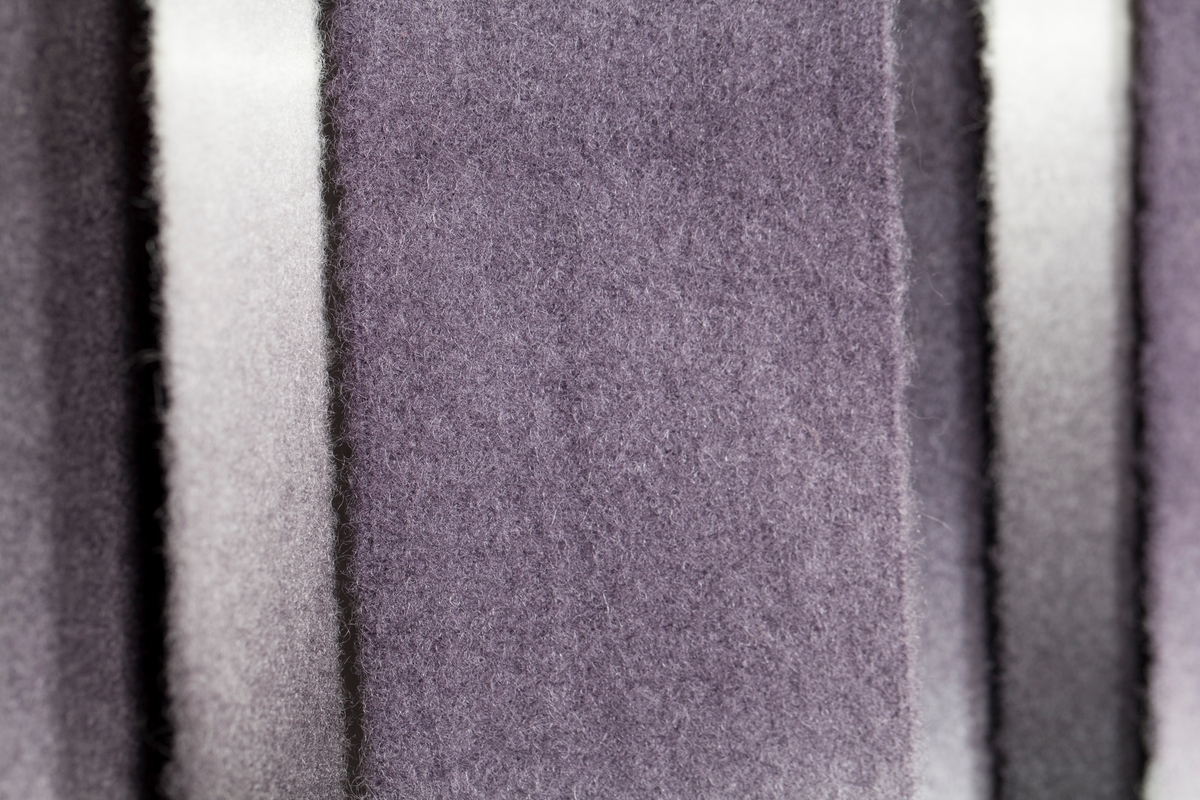 Lange, loddrette remser eller "lameller" av farget ull, delvis sidestilte, delvis overlappende, og farget i den japanske shiboriteknikk, som kunstneren lærte i Japan. Innfarging og plassering av remsene, eller "lamellene", gjør at tekstilet får en metallisk virkning, og spillet mellom lys og skygge frembringer et inntrykk av at dette er remser av blankt metall med et forsterket lyspunkt i sentrum. Remsene er alle vekselsvis mørke og helt lyse, i duse overganger, forskjøvet fargemessig i forhold til hverandre, slik at det fremkommer en optisk illusjon av bølgende metallbånd. Annenhver remse er bred og smal, de bredeste lagt foran de smale, og i tekstilets overkant kan man se endestykkene, der de legger seg over stangen og faller ned i forkant.
