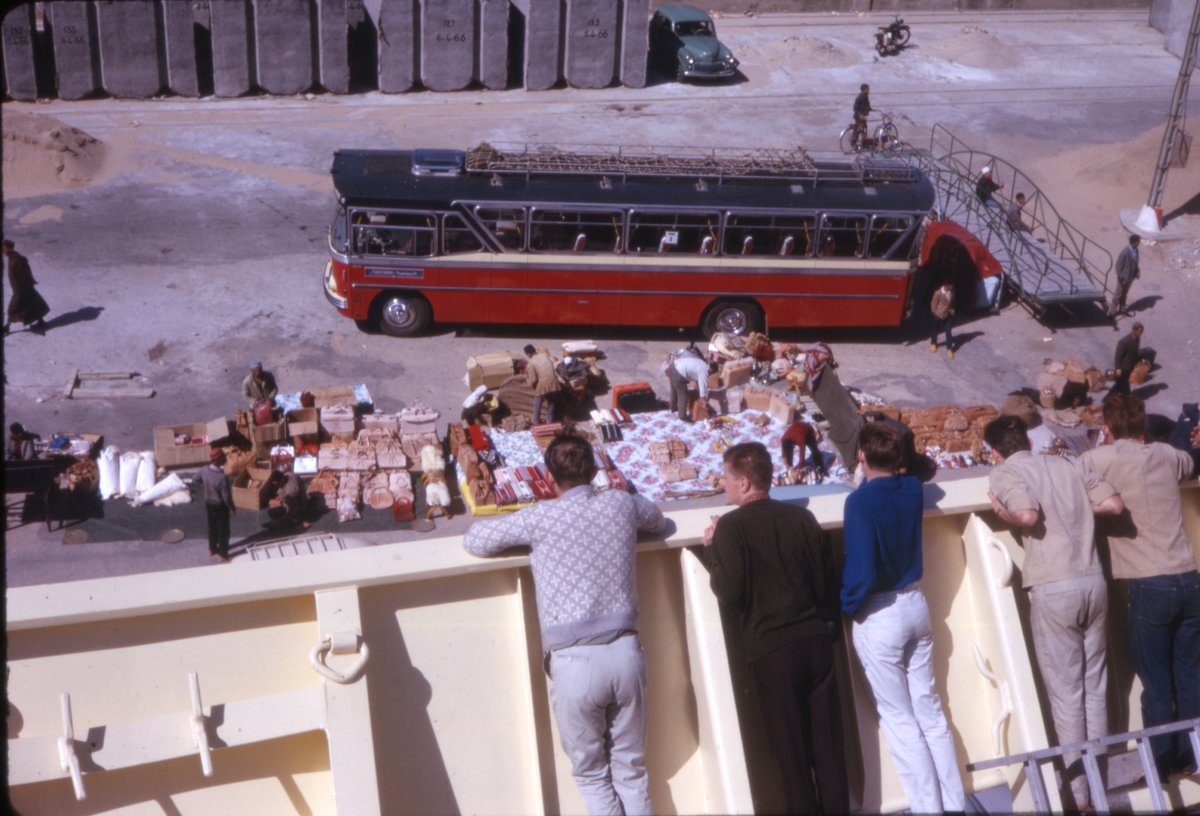 Turister ombord på cruiseskipet 'M/S Sagafjord' følger med på bagasjelossing, trolig i Tanger, Marokko. 'Sagafjord' Spring Cruise to Europe 1966.