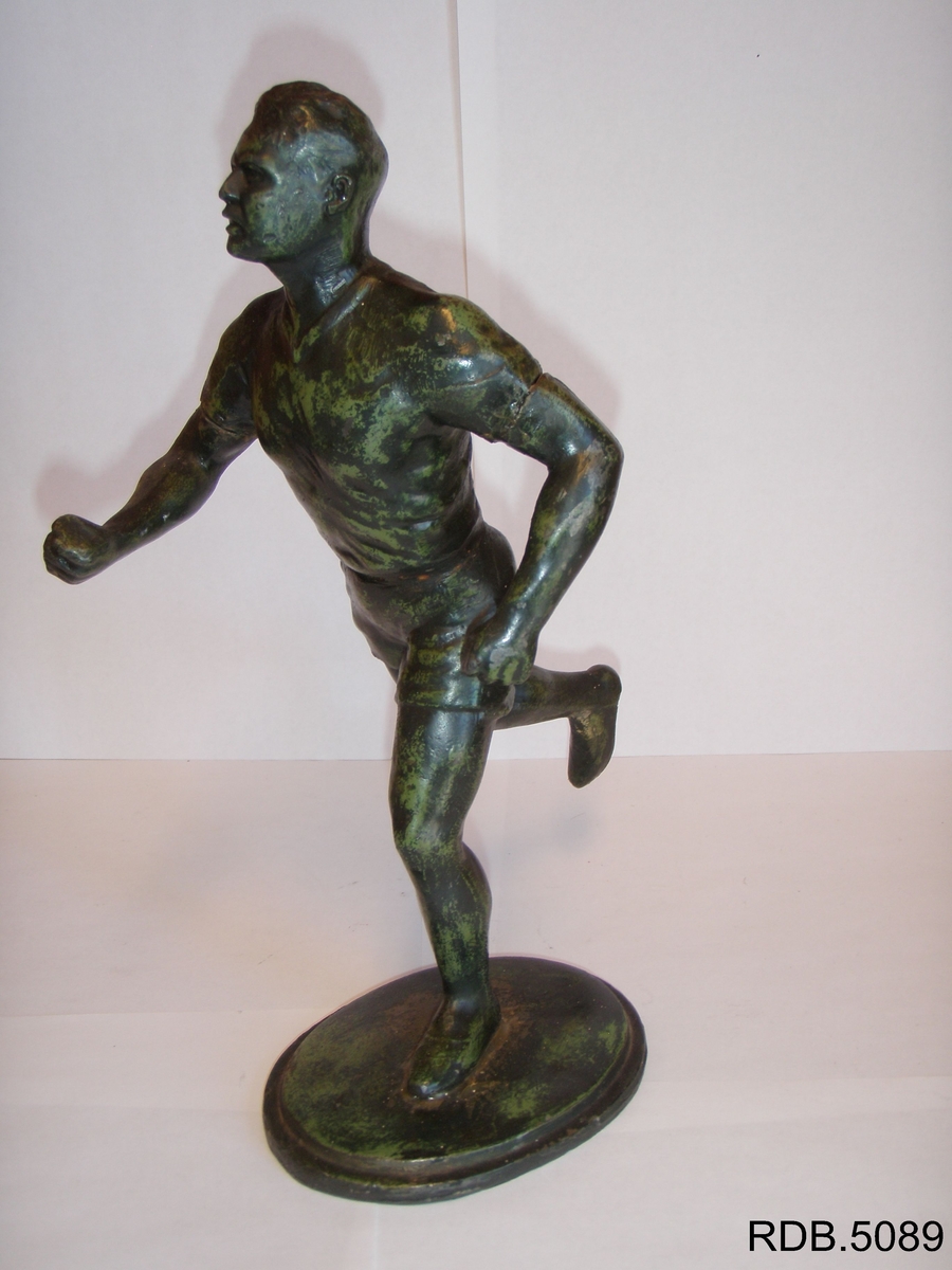 Statuett av en løper. Står på plate.
